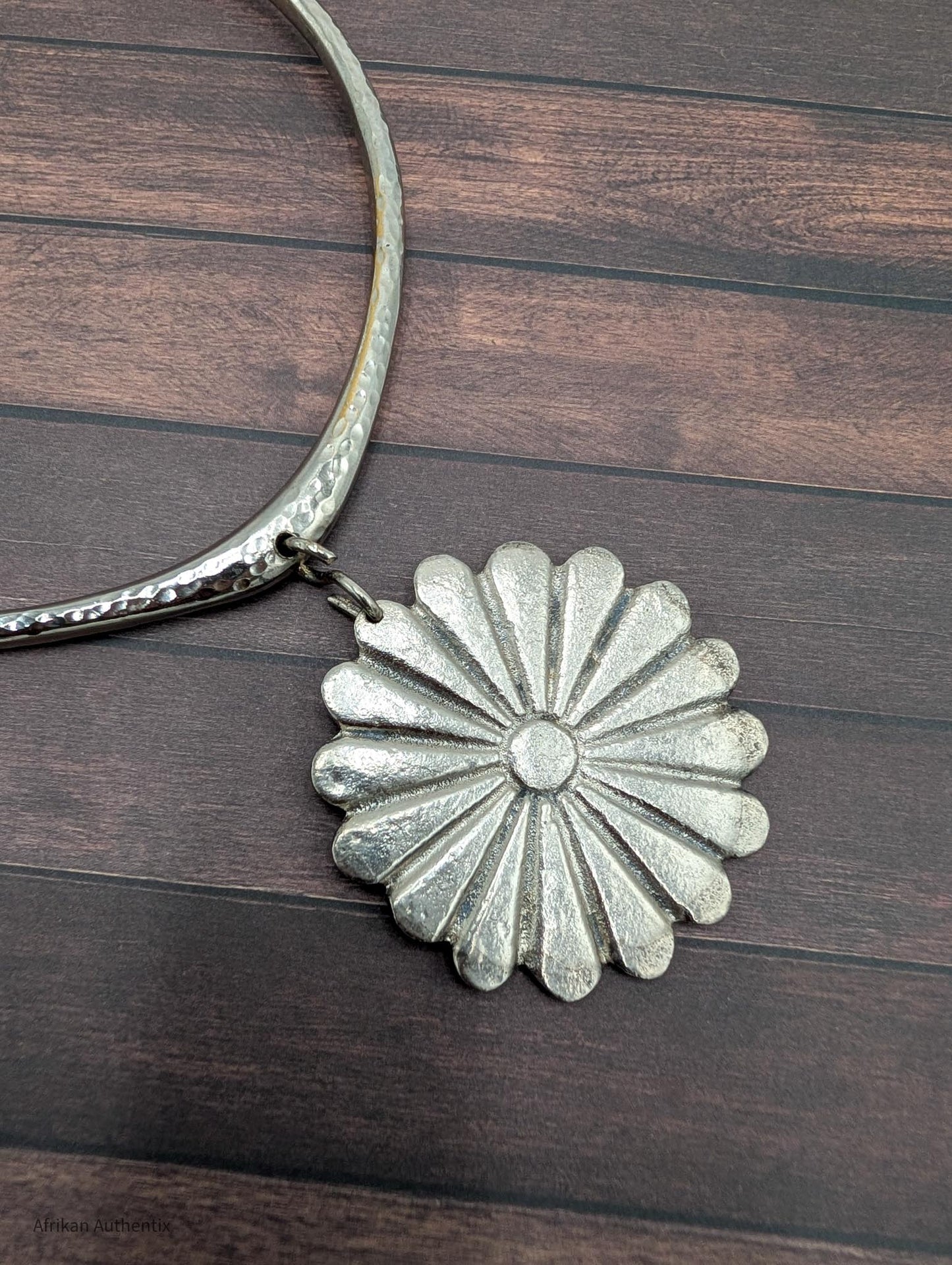 Silver collar necklace with a floral pendant 