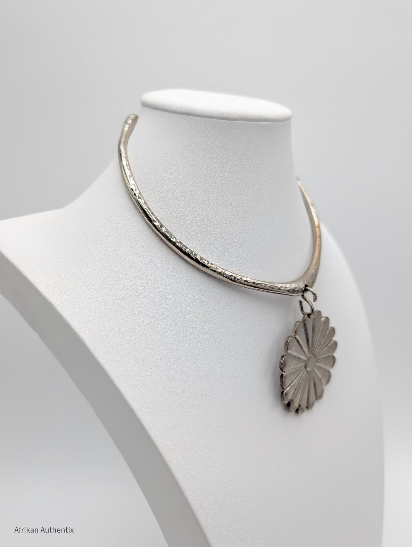 Silver collar necklace with a floral pendant 