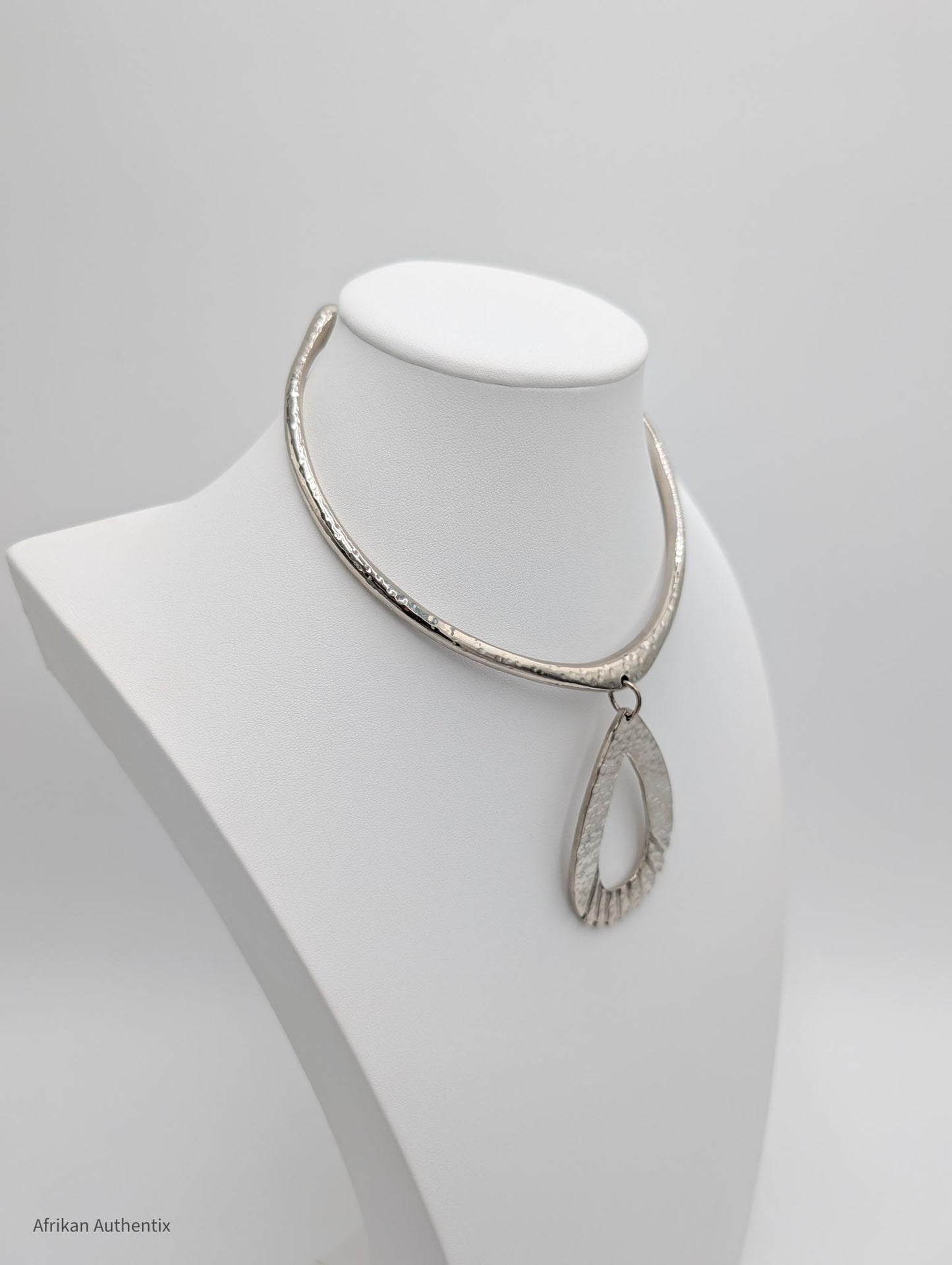 Silver collar necklace on a mannequin bust against a white background