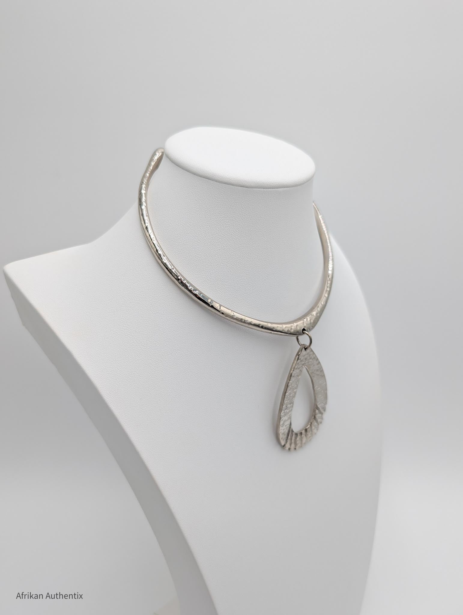 Silver collar necklace on a mannequin bust against a white background