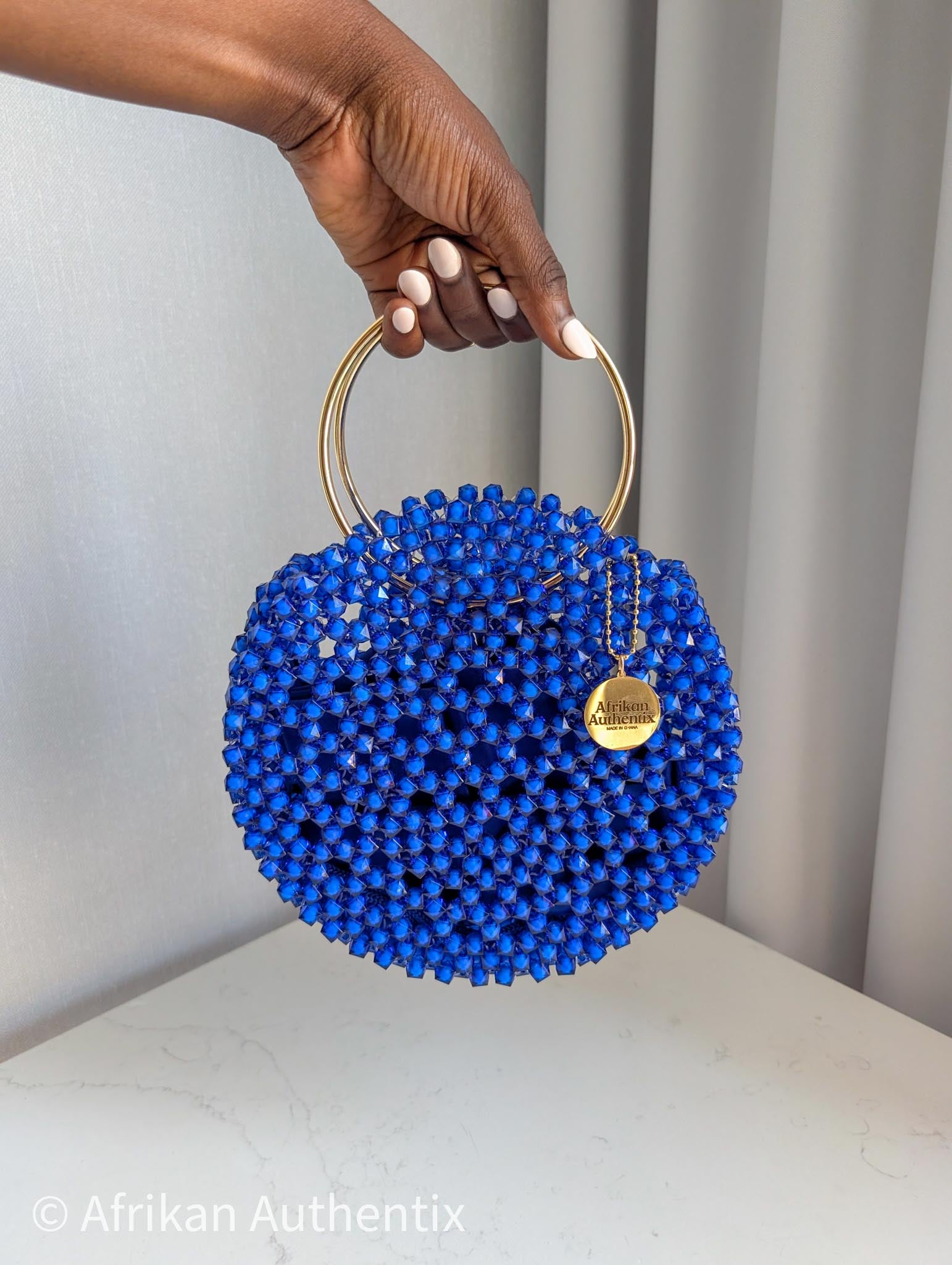 Round blue beaded handbag with gold ring handle handmade in Ghana by Afrikan Authentix