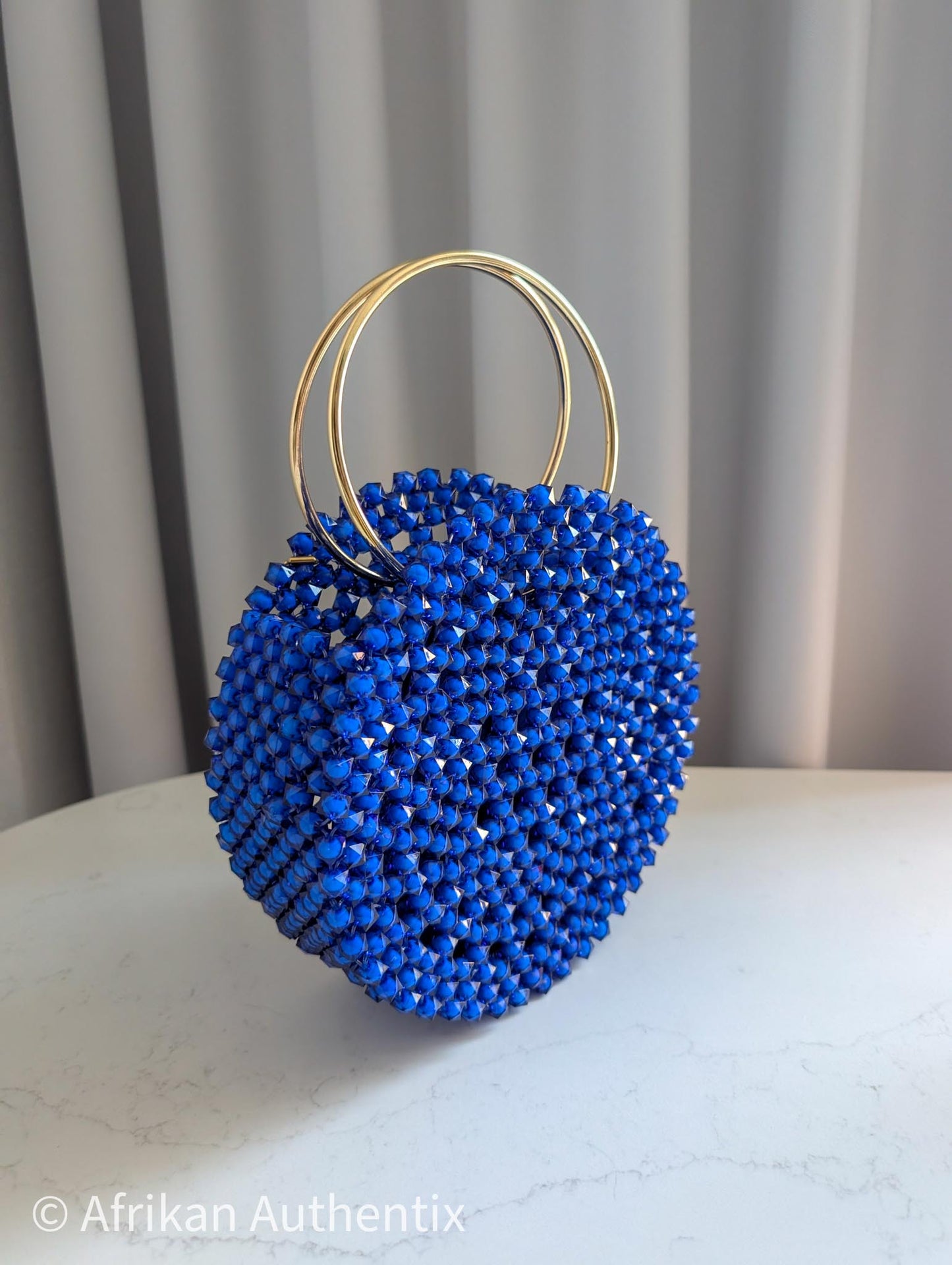Round blue beaded handbag with gold ring handle handmade in Ghana by Afrikan Authentix