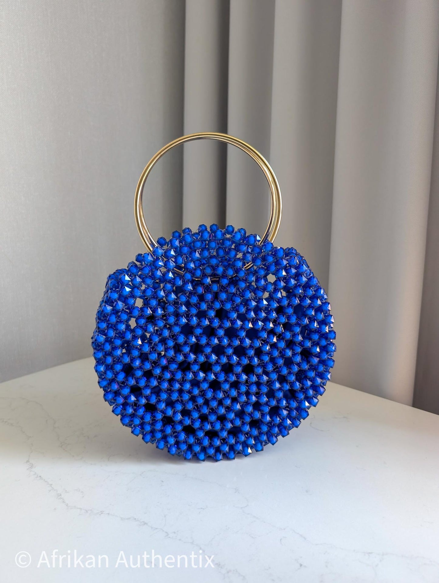 Round blue beaded handbag with gold ring handle handmade in Ghana by Afrikan Authentix