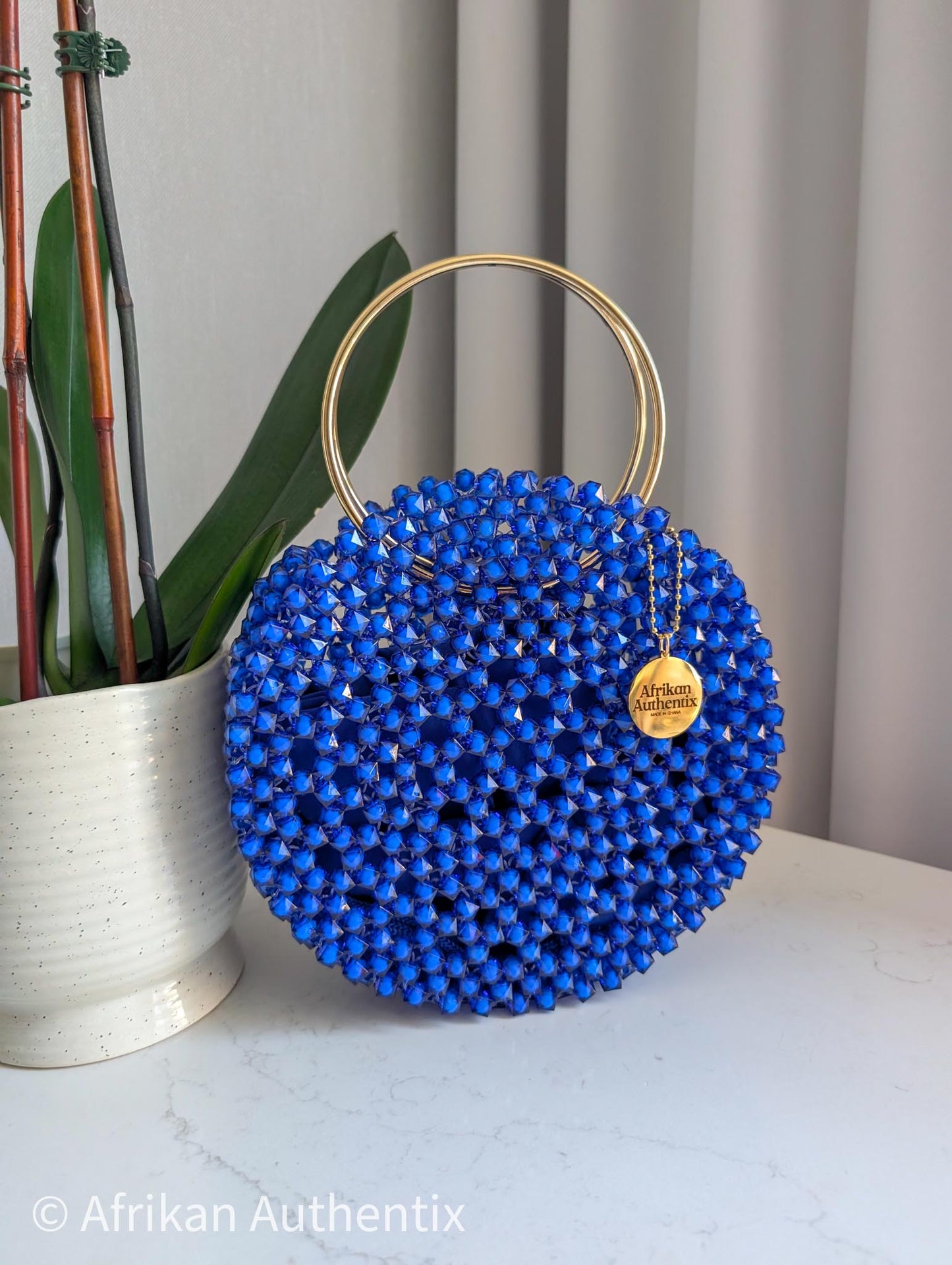 Round blue beaded handbag with gold ring handle handmade in Ghana by Afrikan Authentix