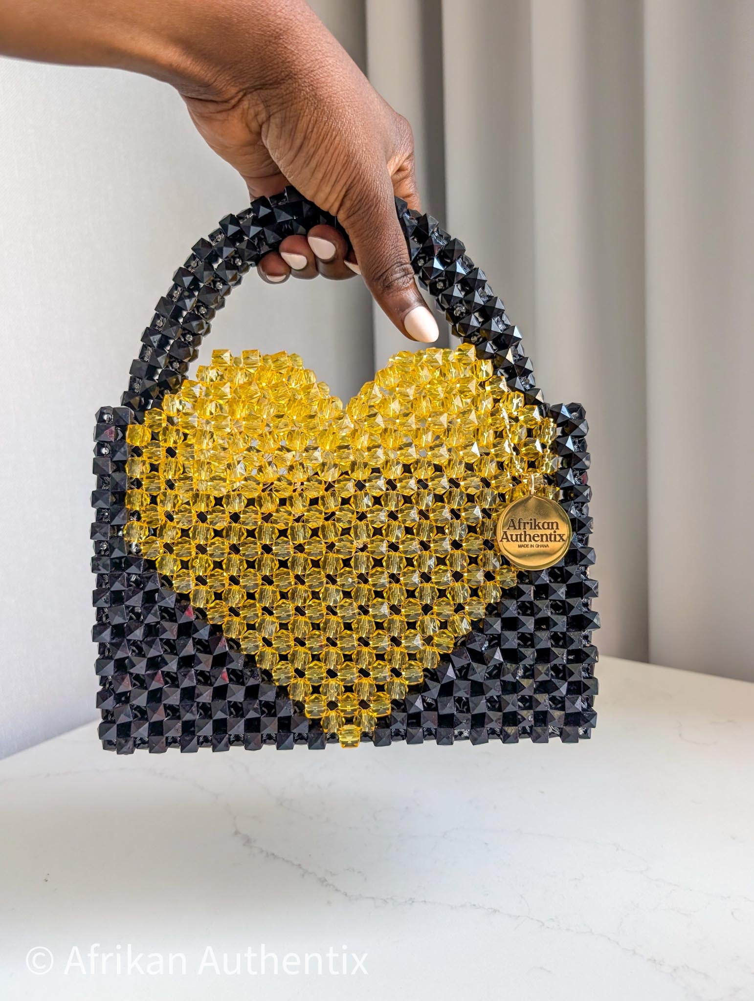 Black and yellow beaded bag with a heart shape bag, featuring the brand 'Afrikan Authentix