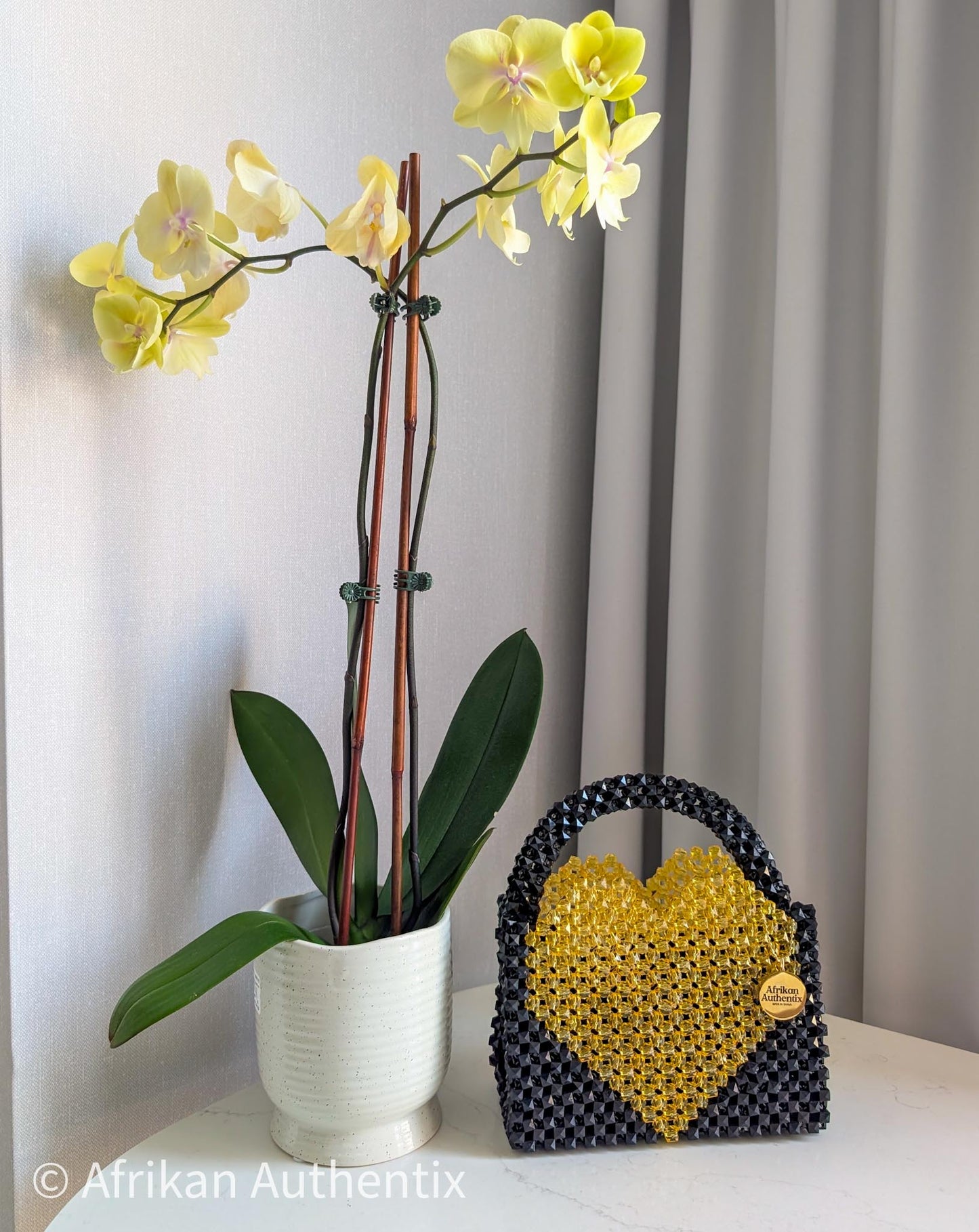 Black and yellow beaded bag with a heart shape bag, featuring the brand 'Afrikan Authentix