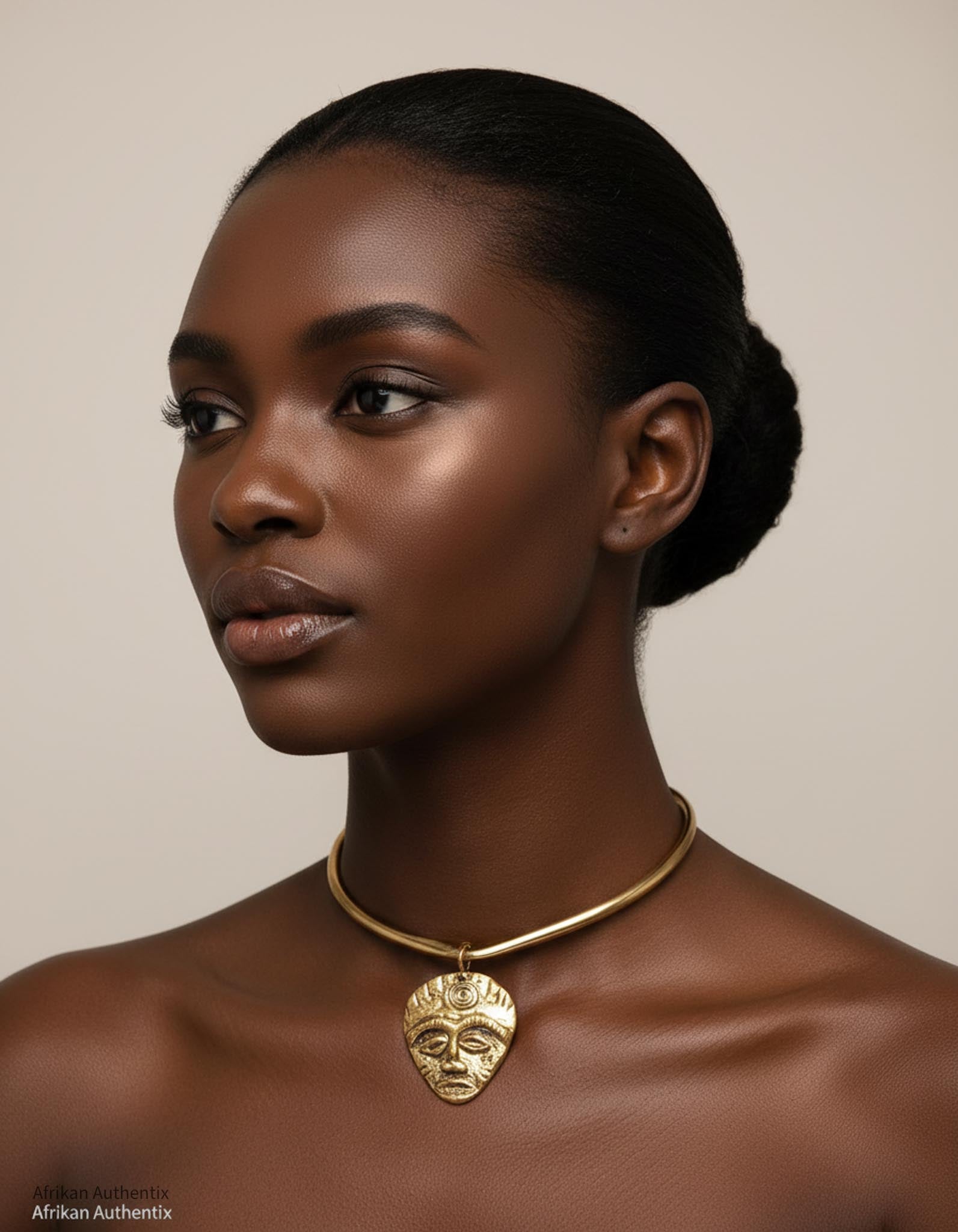 Woman wearing a gold collar necklace with an African mask pendant on a beige background