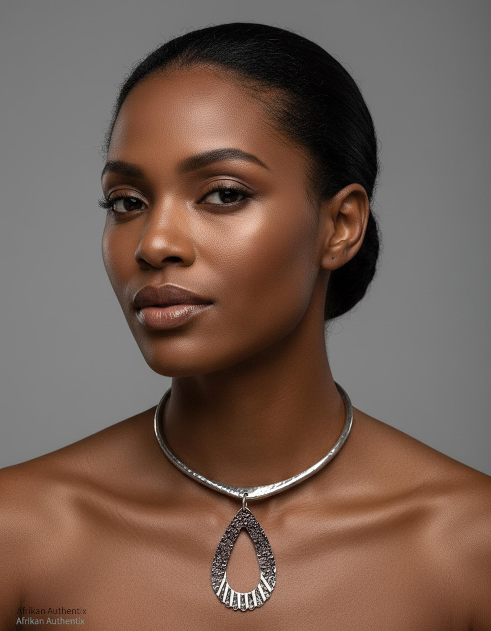 Woman wearing a silver collar necklace against a gray background