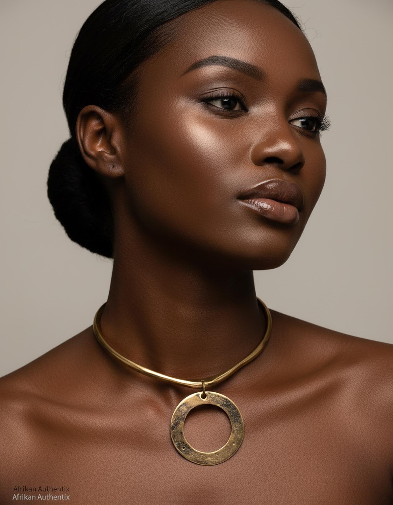Woman wearing a brass collar necklace  against a neutral background